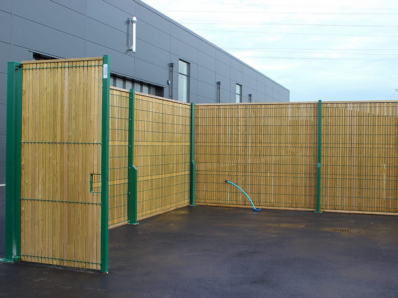 Timber and green mesh fencing for bin storage area