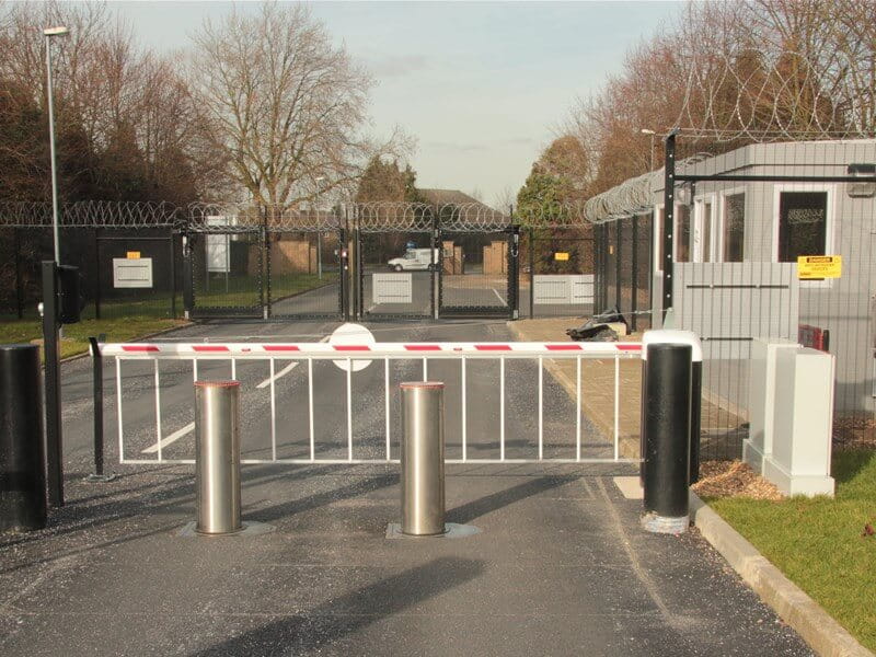 Rising arm barrier with automated bollards